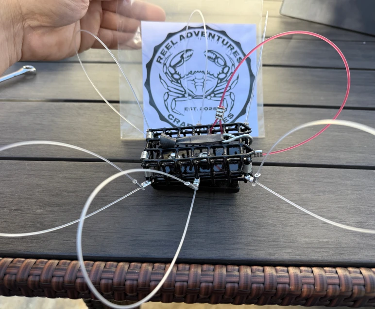 A crab trap with multiple fishing lines on a wooden table.