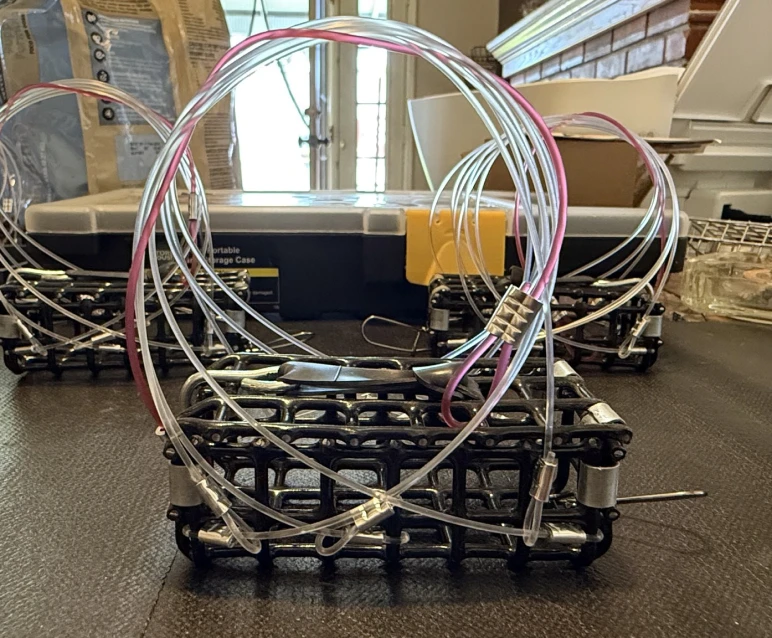 Close-up of a wire trap device on a table with other similar traps in the background.